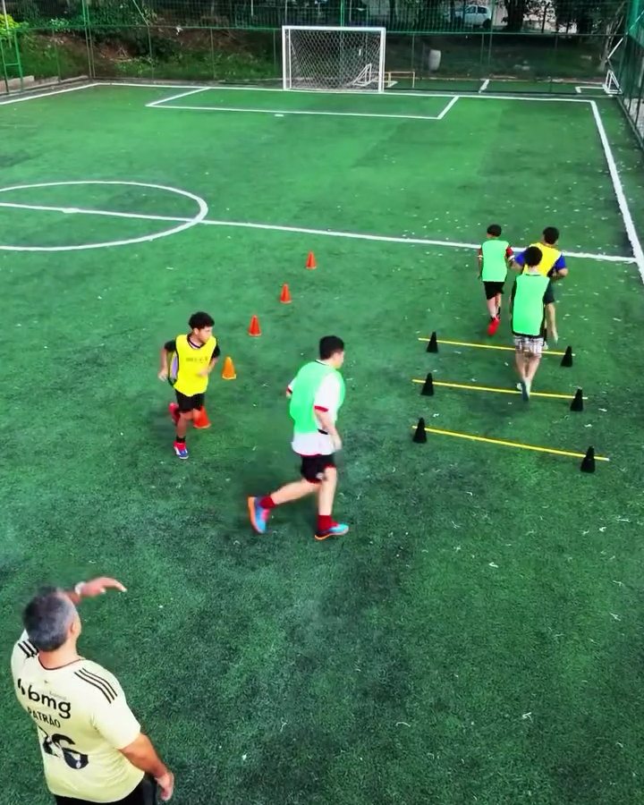 Alunos em circuito de agilidade com escada e cones no campo
